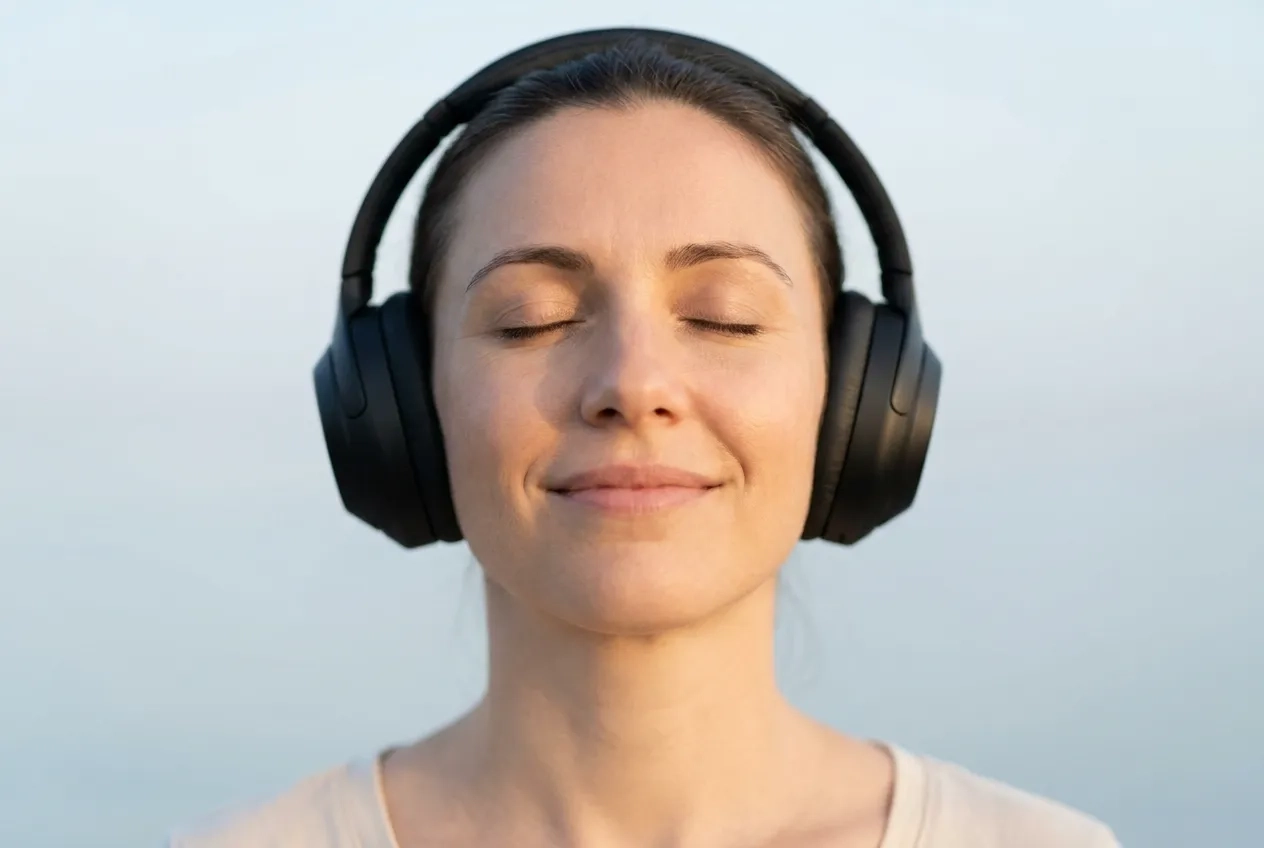 Personne écoutant une séance de méditation audio avec un casque pour favoriser la relaxation et réduire le stress avec SoundTao.